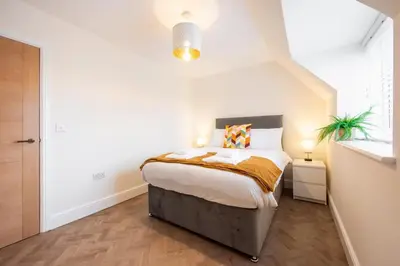 a bedroom with a bed in a white room at 8 The Royal Serviced Apartments ,Harwich, One Bed Parking, Fast Wifi, Space Apartments in Parkeston