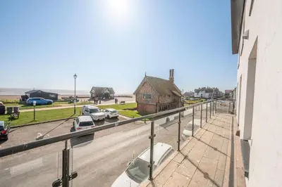 a balcony of a building with cars parked in a parking lot at Market Cross House, Aldeburgh. Sea front holiday home in Aldeburgh