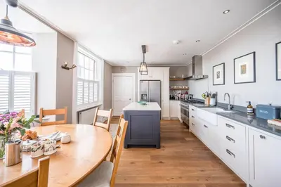 a kitchen with a wooden table and a dining room at Market Cross House, Aldeburgh. Sea front holiday home in Aldeburgh