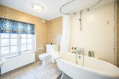 a bathroom with a tub and a toilet and a sink at Market Cross House, Aldeburgh. Sea front holiday home in Aldeburgh