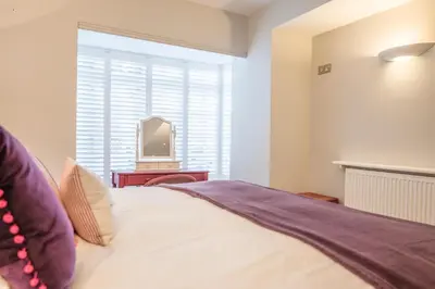 a bedroom with a bed and a tv in a window at Market Cross House, Aldeburgh. Sea front holiday home in Aldeburgh