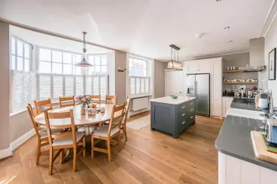 a kitchen and dining room with a table and chairs at Market Cross House, Aldeburgh. Sea front holiday home in Aldeburgh