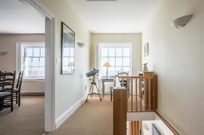 a hallway with a room with a table and windows at Market Cross House, Aldeburgh. Sea front holiday home in Aldeburgh