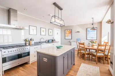 a kitchen and dining room with a dining table at Market Cross House, Aldeburgh. Sea front holiday home in Aldeburgh