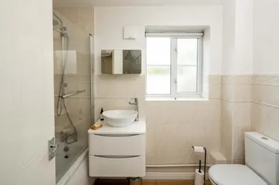 a white bathroom with a sink and a shower at Loughton Hideaway: Cozy 1BD Near Tube & Nature in Theydon Bois