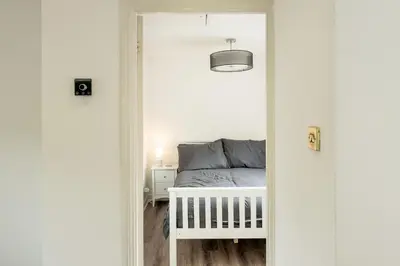 a bedroom with a bed in a white room at Loughton Hideaway: Cozy 1BD Near Tube & Nature in Theydon Bois