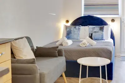 a bedroom with a bed and a couch and a table at Pass the Keys Stylish and modern apartment in Cambridge