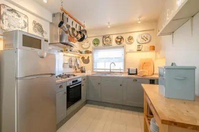 a kitchen with a refrigerator and a sink at Seagulls - Aldeburgh Coastal Cottages in Aldeburgh