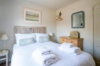 a bedroom with a bed with towels on it at Seagulls - Aldeburgh Coastal Cottages in Aldeburgh
