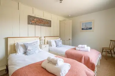 a bedroom with two beds with towels on them at Seagulls - Aldeburgh Coastal Cottages in Aldeburgh