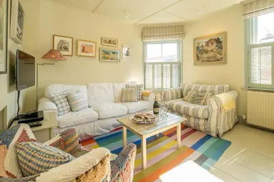 a living room with a couch and a table at Seagulls - Aldeburgh Coastal Cottages in Aldeburgh
