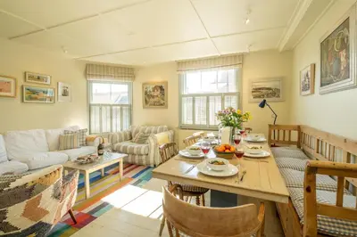 a living room with a table and a couch at Seagulls - Aldeburgh Coastal Cottages in Aldeburgh