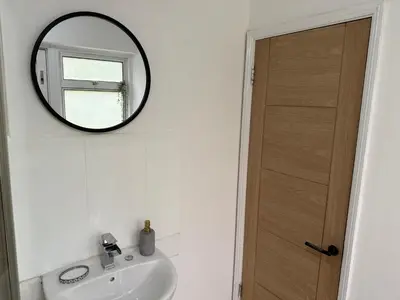 a bathroom with a sink and a mirror on the wall at Apartment close to London Stansted airport in Great Parndon