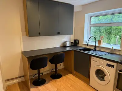 a kitchen with a sink and a washing machine at Apartment close to London Stansted airport in Great Parndon