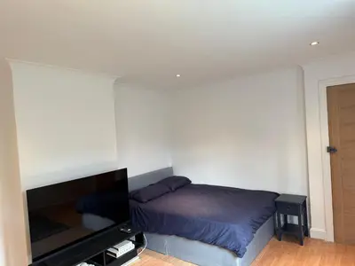 a bedroom with a bed and a flat screen tv at Apartment close to London Stansted airport in Great Parndon