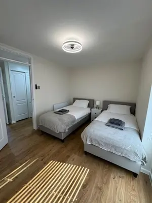 two beds in a room with wooden floors at Fantastic family flat in Frinton in Kirby Cross