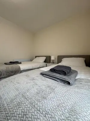 a bedroom with two beds with towels on them at Fantastic family flat in Frinton in Kirby Cross