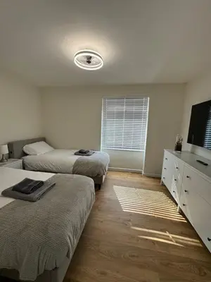 a bedroom with two beds and a flat screen tv at Fantastic family flat in Frinton in Kirby Cross