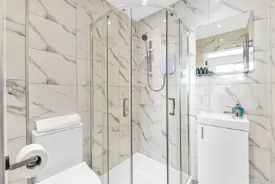 a bathroom with a shower with a toilet and a sink at Studio Society - Stay, Cook, and Connect in Southend-on-Sea