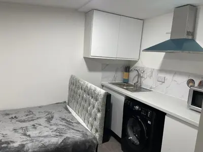a kitchen with a washing machine in a kitchen at Cozy mini studio in Basildon in Nevendon