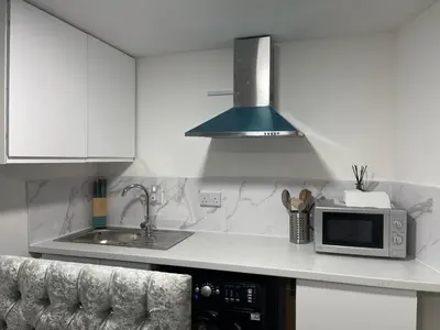 a kitchen with a microwave and a sink at Cozy mini studio in Basildon in Nevendon