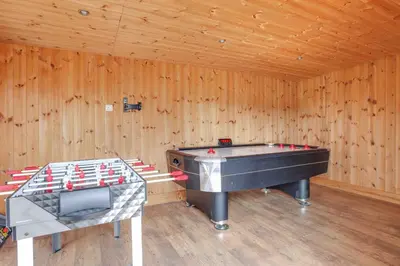 a ping pong table in a wooden room with a pool table at Wayside Warren Harlow in Potter Street