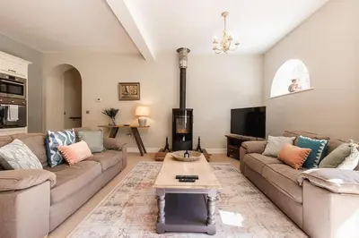 a living room with two couches and a fireplace at Stylish Coach House Retreat in Wymondham
