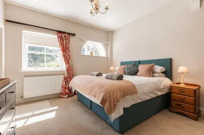 a bedroom with a large bed and a window at Stylish Coach House Retreat in Wymondham