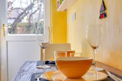 a table with two wine glasses and a bowl on it at Pass the Keys Charming Ground Floor Flat with Free Parking in Cambridge