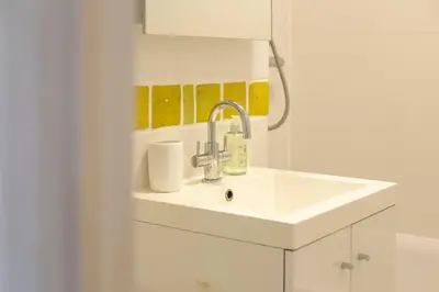 a white bathroom with a sink and a mirror at Pass the Keys Charming Ground Floor Flat with Free Parking in Cambridge