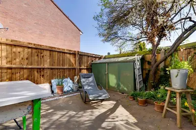 a backyard with a fence and a chair at Pass the Keys Charming Ground Floor Flat with Free Parking in Cambridge