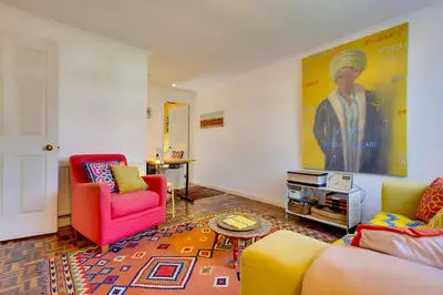 a living room with colorful furniture and a painting on the wall at Pass the Keys Charming Ground Floor Flat with Free Parking in Cambridge