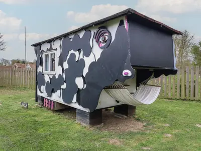 a black and white dog house in a yard at Buttercup Cow Shed 3 in Woodbridge
