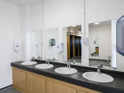 a bathroom with three sinks and a large mirror at Buttercup Cow Shed 3 in Woodbridge