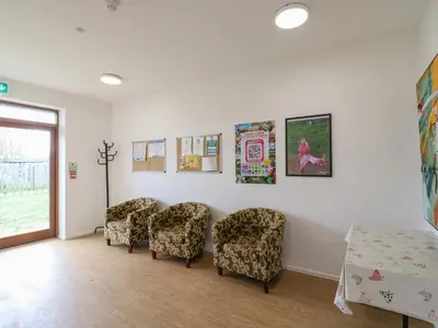 a waiting room with chairs and posters on the wall at Buttercup Cow Shed 3 in Woodbridge