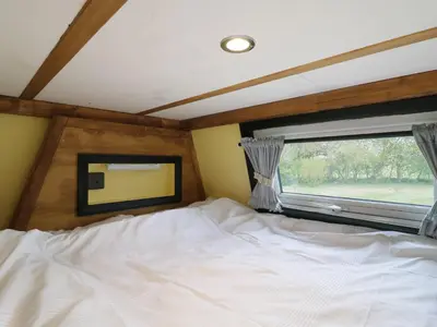 a bedroom with a large bed and a window at Betsy Cow Shed 2 in Woodbridge