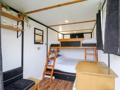 a small room with bunk beds and a desk at Bluebelle Cow Shed 5 in Woodbridge