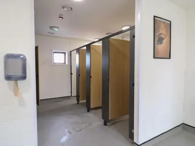 a row of stalls in a hallway with a tv at Daisy Cow Shed 1 in Woodbridge