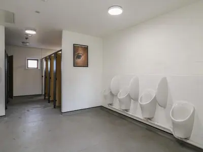 a bathroom with a row of urinals on the wall at Daisy Cow Shed 1 in Woodbridge