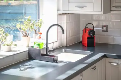 a kitchen with a sink and a red backpack at Modern Spacious 4 Bedroom 3 Bathroom House by Trinity Stays Short Term Lets & Serviced Accommodation Cambridge in Cambridge