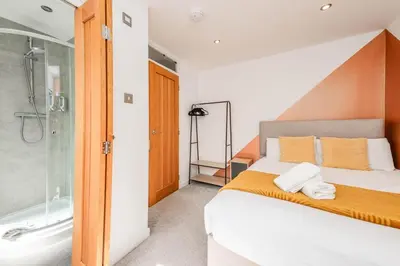 a bedroom with a large bed and a shower at Modern Spacious 4 Bedroom 3 Bathroom House by Trinity Stays Short Term Lets & Serviced Accommodation Cambridge in Cambridge