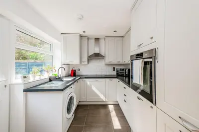 a white kitchen with a sink and a dishwasher at Modern Spacious 4 Bedroom 3 Bathroom House by Trinity Stays Short Term Lets & Serviced Accommodation Cambridge in Cambridge