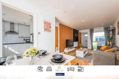 a kitchen and a living room with a table at Modern Spacious 4 Bedroom 3 Bathroom House by Trinity Stays Short Term Lets & Serviced Accommodation Cambridge in Cambridge