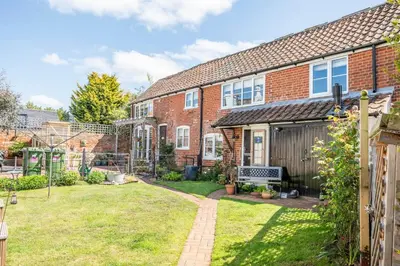 a brick house with a garden in front of it at Stable Cottage, Friston in Friston