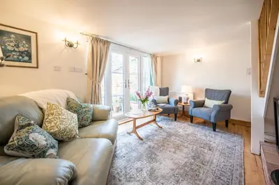 a living room with a couch and two chairs at Stable Cottage, Friston in Friston