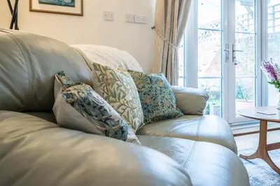 a leather couch with pillows on it in a living room at Stable Cottage, Friston in Friston