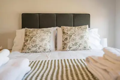 a bed with two pillows and a head board at Stable Cottage, Friston in Friston