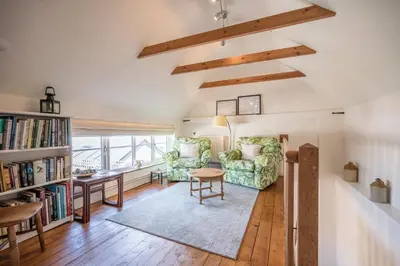 a living room with a desk and a chair and a table at Stable Cottage, Friston in Friston