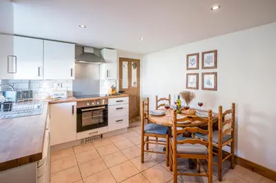 a kitchen with a table and chairs in a room at Stable Cottage, Friston in Friston