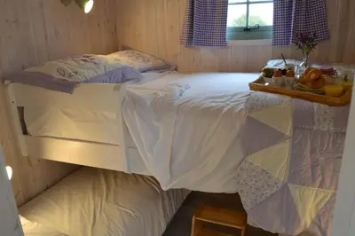 a bedroom with a bed with a tray of fruit on it at Shepherds Hut 7 in Bedfield
